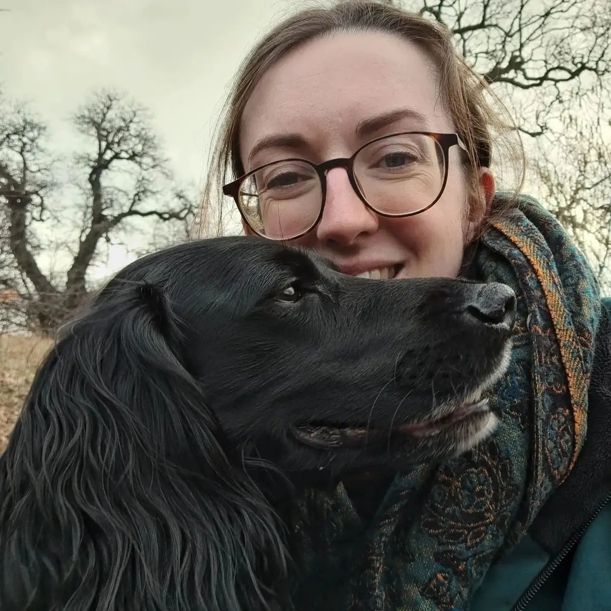 Rosy smiling with her black spaniel beside her
