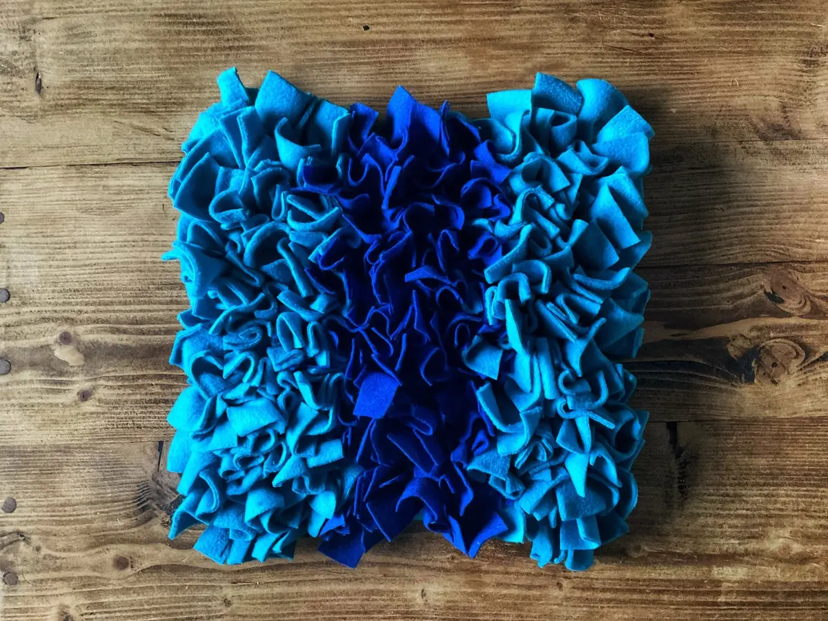 A blue snuffle mat on a wooden table