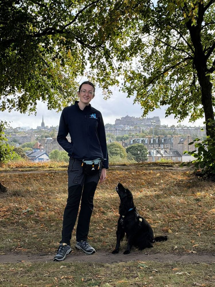 Rosy with her spaniel looking up at her, Edinburgh Castle on the skyline behind